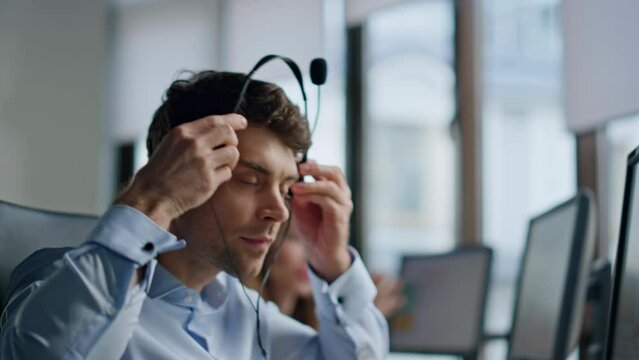 Call operator hand taking headset closeup. Support professional talking customer