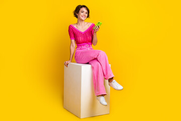 Full body size photo cadre of youngster woman chilling sit platform hold smartphone browsing her gadget internet isolated on yellow color background