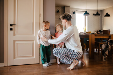 Father measuring height of his kids and marking it on wall