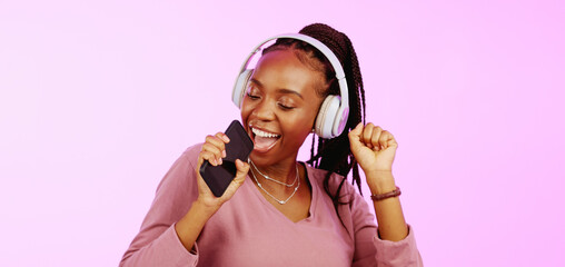 Sing, dance and black woman with headphones music microphone isolated on a studio background. Fun, happy and funky African girl listening to audio, radio or songs while singing and dancing on a backd
