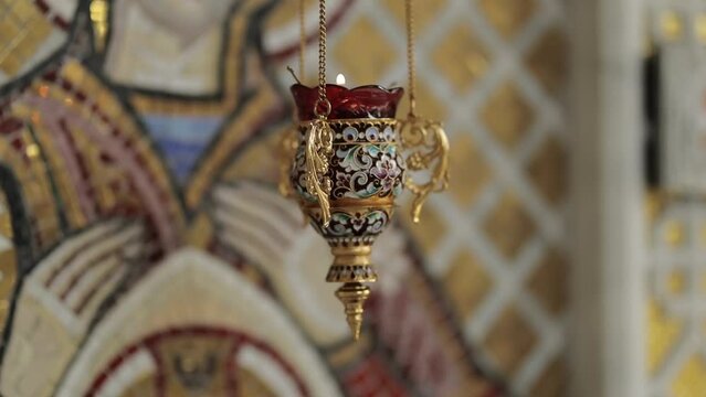 Golden Icon lamp. Golden lampad in front of the icons in the Orthodox Church. Lampad in the church, a burning candle. Orthodox icons in the church. religious concept. Gilded church altarpieces.