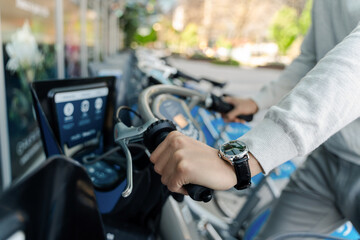 Selective focus, closeup of man holding handlebars of rental bicycle outdoors