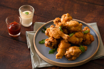 Closed up fried chicken drumsticks on plate, homemade appetizer and fast food, ketchup and mayonnaise sauce
