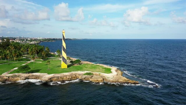Aerial view of yellow lighthouse Faro San Souci at Punta Torrecilla on the rocky shore. The port of Santo Domingo, Dominican Republic