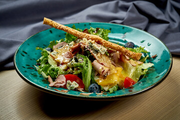 Salad with duck, tomatoes and mango sauce in a plate