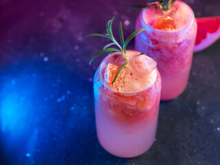 grapefruit tonic glasses with crushed ice, grapefruit slice and rosemary. color light background