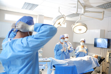 A team of doctors and medical assistants are operating on a patient inside the operating room.