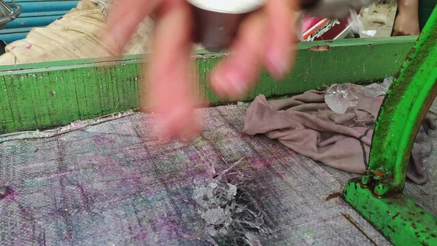 Closeup of male hands making an iced popsicle or ice gola with crushed ice