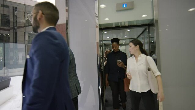 Office workers exiting a lobby lift in a corporate building