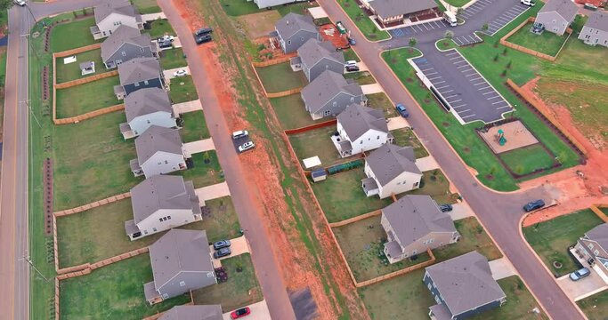 Aerial view showcases an expansive unfinished subdivision housing complex, with rows of houses in various stages of construction