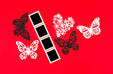 The Cinema strip photo paper frames with butterfly paper on red background. Save clipping path.