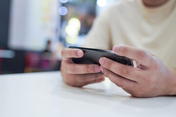 Man playing game on mobile phone. gamer boy playing video games holding Smartphone working mobile devices. cell telephone technology e-commerce concept