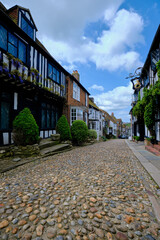 Fototapeta na wymiar Rye, East Sussex, England, Europe - May 18, 2023: The Mermaid - ancient hotel on a cobblestoned street. A small English medieval coastal town on a sunny day.