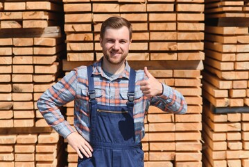 Carpenter in uniform check boards on sawmill