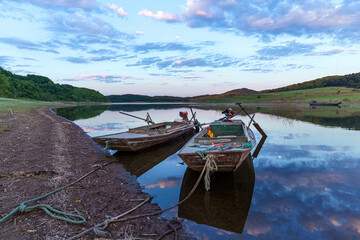 Obraz premium Small iron boat docked by the water