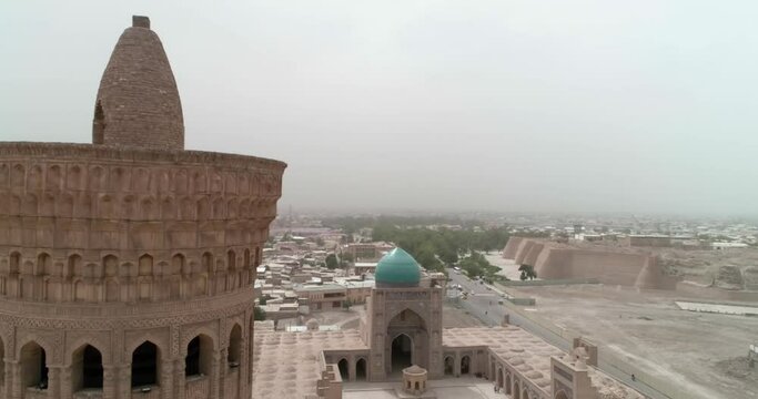 A drone flies around the famous memorial complex Kalyan Poi Kalon Complex and Poi Kalon Minaret, Poi Kalan or Po-i-Kalyan in Bukhara at dawn