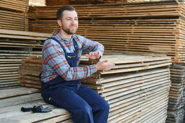 Male Worker folds boards. Sawmill. Wood harvesting process