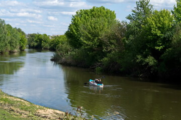 Fototapeta na wymiar Kayaking on river with dark water Sunny day Blue sky paddling in kayak on dark water of Styr River during sunny day in Ukraine Active recreation Sport Hobby