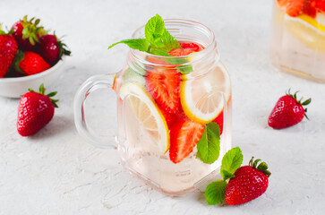 Strawberry Infused Water, Refreshing Cocktail, Lemonade, Detox Iced Drink with Fresh Strawberry, Lemon and Mint on Bright Background