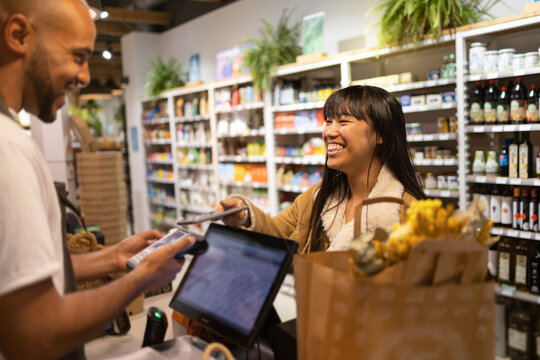 Happy customer paying with smartphone for purchases
