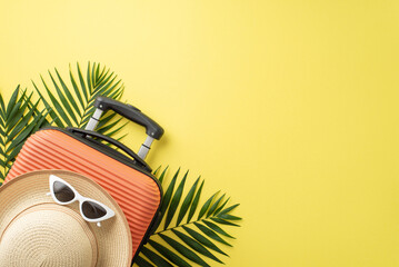 Tropical travel essentials. Overhead shot of a vibrant orange suitcase, beach gear, eyeglasses,...