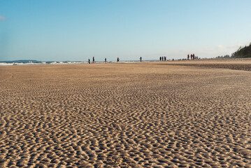 View of sandy beach against blue sky. Late afternoon.