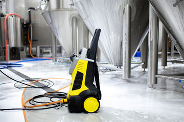 high pressure water cleaner of black and yellow color, put on the floor in warehouse