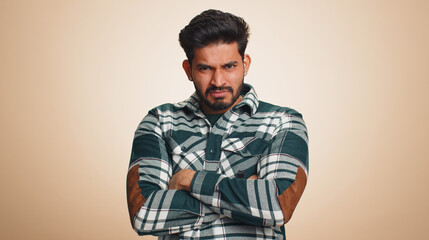 Obraz premium Indian man in shirt screams yell from stress tension problems feels horror hopelessness fear panic surprise shock expresses gestures rage. Handsome hindu guy isolated on beige studio background