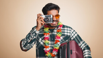 Happy indian man tourist photographer in sunglasses taking pictures photos on retro camera. Travel,...