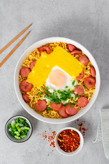 Ramen Noodles with Sausages, Egg, Melted Cheese and Scallion, Microwave Shin Ramyeon or Ramyun on Bright Background