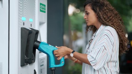 Video of beautiful woman charging electro car at the electric gas station