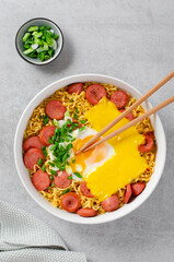Ramen Noodles with Sausages, Egg, Melted Cheese and Scallion, Microwave Shin Ramyeon or Ramyun on Bright Background