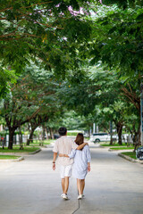 Fototapeta na wymiar Man and woman tourist relax and enjoy outdoor lifestyle and holiday vacation. beautiful young couple walking at the park