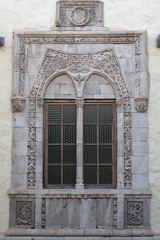 Detail of a very nice decorated old window, stone facade