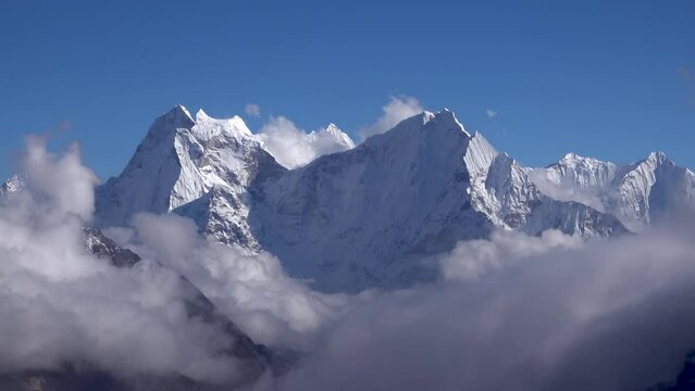Huge Himalaya mountain in clouds and blue sky with snow
Long shot view from Nepal, 2023


