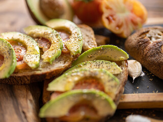 Freshly baked rye sourdough sliced organic artisan bread with tomato, garlic, EVO oil, avocado, salt