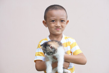 Obraz premium Asian boy smiling happily with his pet cat