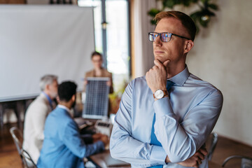 Portrait of confident young businessman during team meeting.