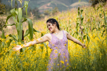 Foto de hermosa mujer feliz sonriendo y caminando en el bosque de flores amarillo ,con una corona...