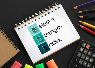 RSI - Relative Strength Index acronym on notepad, business concept background