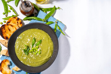 Homemade green pea cream soup, green gazpacho cold soup with peas decor and croutons, tasty vegan food, diet dinner recipe