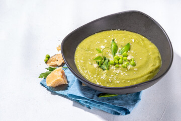 Homemade green pea cream soup, green gazpacho cold soup with peas decor and croutons, tasty vegan food, diet dinner recipe