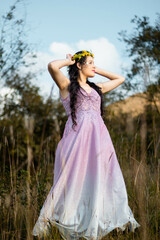 una mujer hermosa con un vestido ligero en un campo  con las manos levantadas sobre su cabeza en...