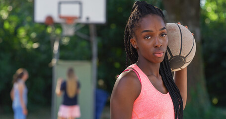 Portrait of Beautiful Black Young Woman Holding a Basket Ball While Looking at the Camera in an...