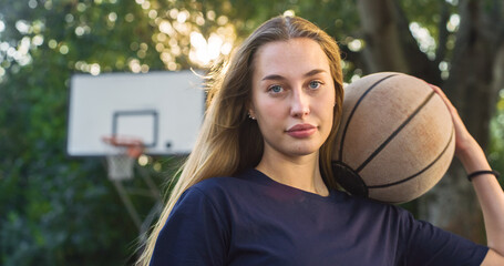 Portrait of Beautiful Blond Young Woman Holding a Basket Ball While Looking at the Camera in an...
