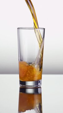 Vertical shot of a beer glass being filled with beer. Slow Motion.