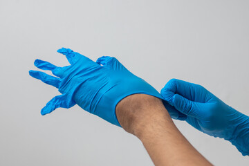 Male hand wearing blue latex gloves, medical, protective, white background