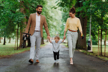 Obraz premium Young family with little son on walk after work.