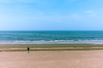Fototapeta na wymiar A guy walking on a beach in Enoshima