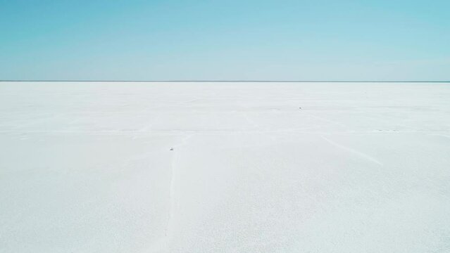 Aerial wide view of salt lake coast. Baskunchak in high tourist season at bright sunny day. Unique lake in the southwest of Russia, medicinal clay and mud deposite